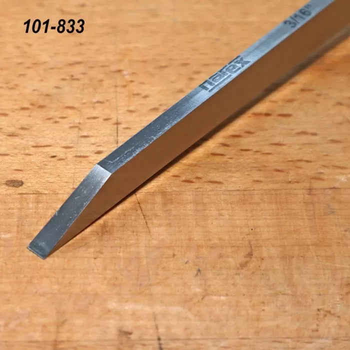 Steel woodworking chisel with beveled edge on wooden workbench, tool number 101-833
