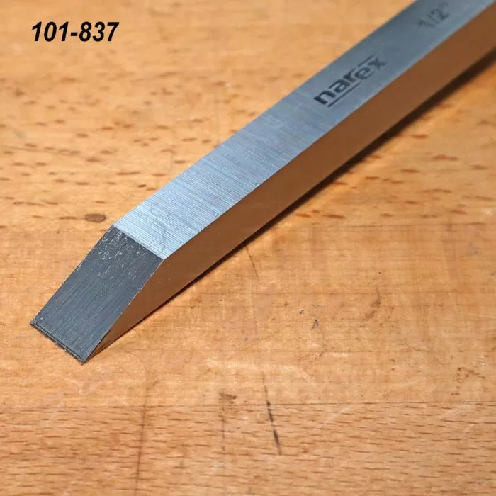 Steel woodworking chisel with beveled edge on wooden workbench