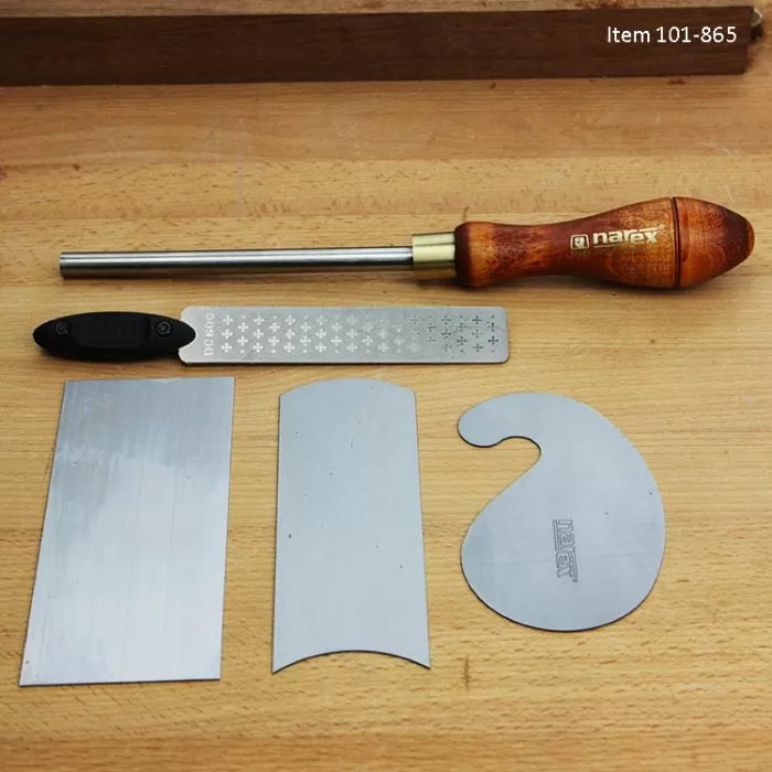 Woodworking scraper set with burnisher, file, and three cabinet scraper blades on workbench