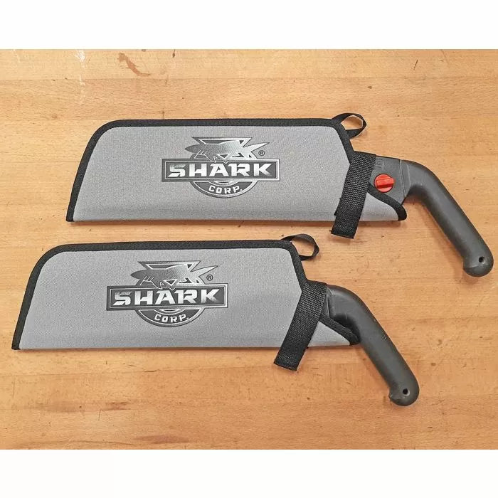 Two Shark Corp woodworking hand saws with gray blade covers on a wooden surface.