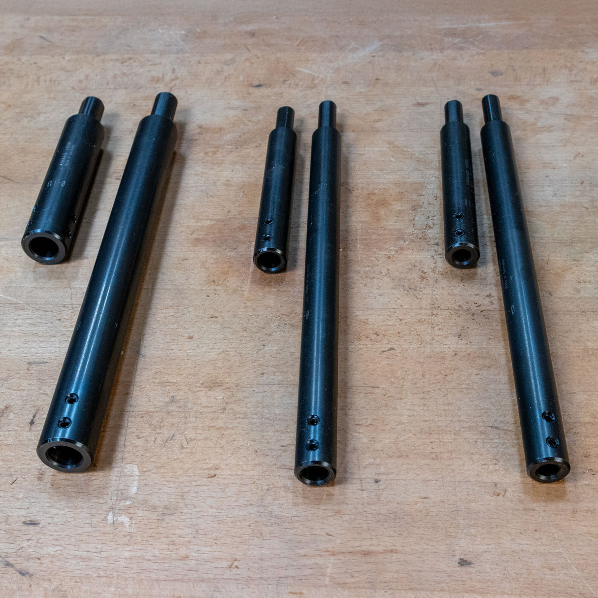 Three-piece set of black steel woodworking jig rods on a workbench