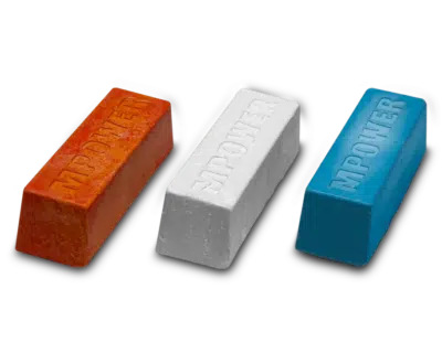 Three wood finishing wax bars in orange, white, and blue on a black background.