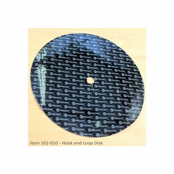 Round hook and loop sanding disk with center hole on a wood surface