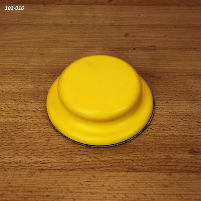 Yellow hand sanding pad for woodworking on a wood surface