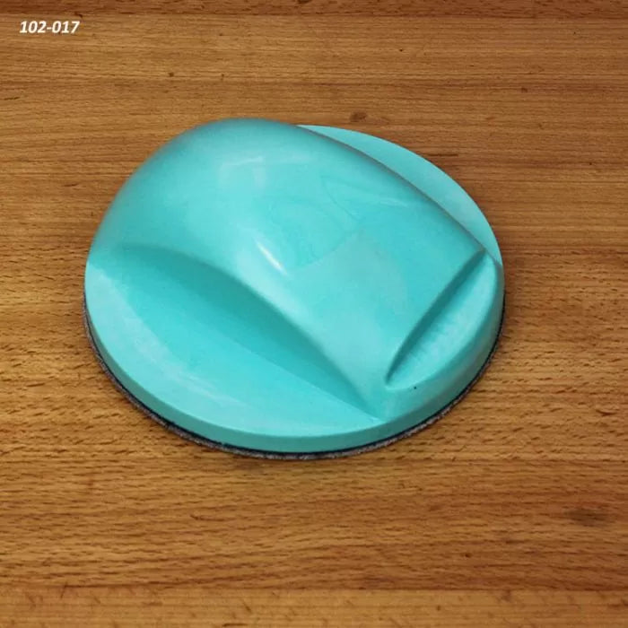 Blue hand sanding block on a wooden surface, woodworking tool for smoothing wood.