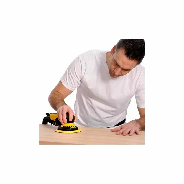Man using a yellow electric sander on a wooden surface for woodworking project