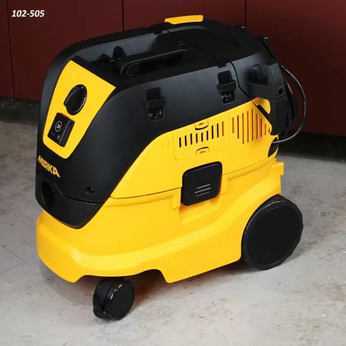 Yellow and black portable shop dust extractor vacuum on a workshop floor
