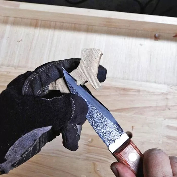 Gloved hand carving wood with detail knife on workbench, woodworking tools in use