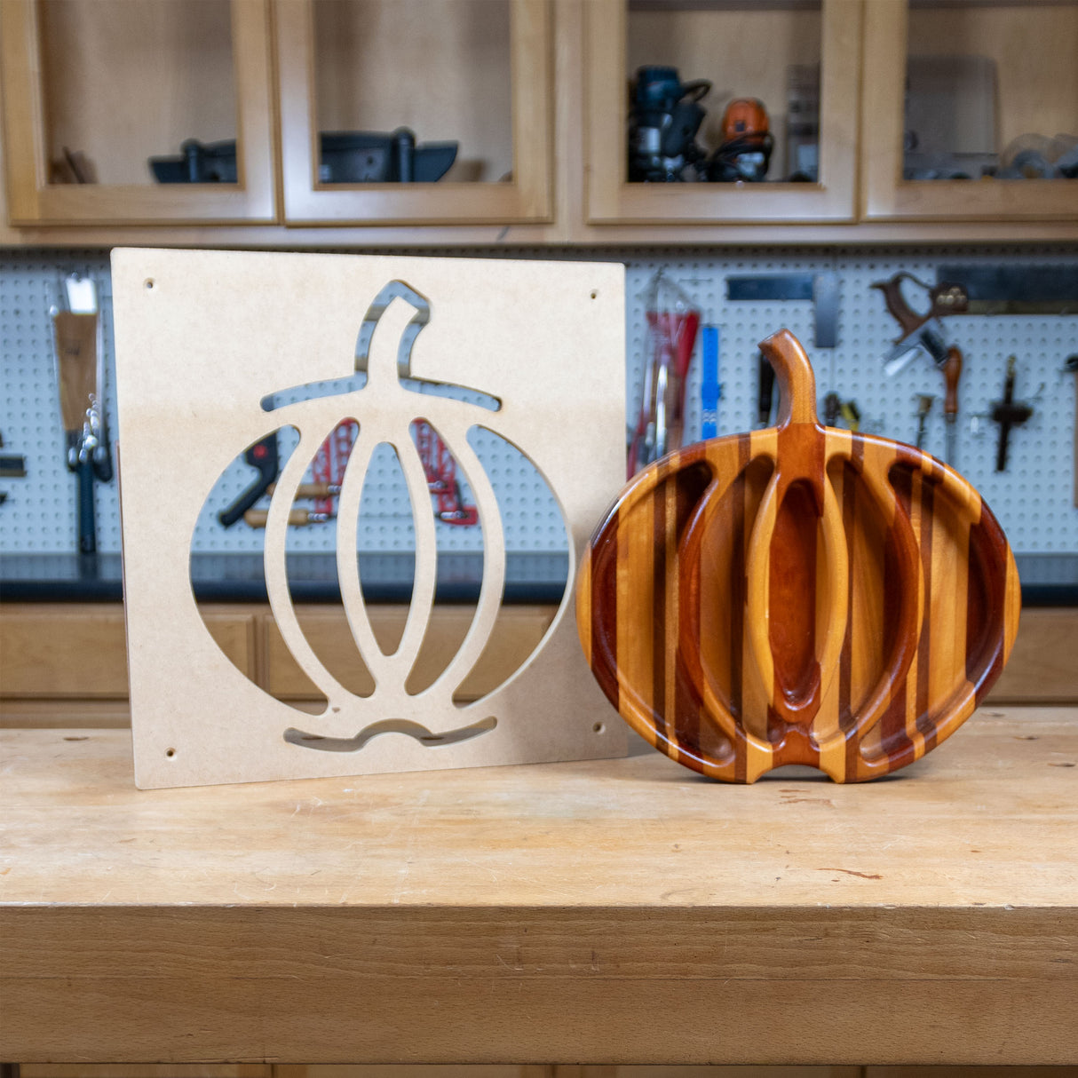 Pumpkin tray woodworking template and finished wooden pumpkin tray on a workbench