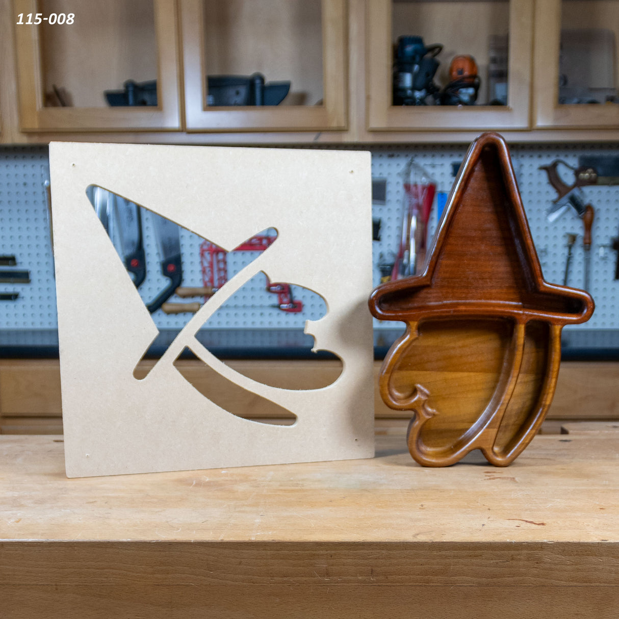 Wooden witch tray with matching MDF template for woodworking projects on a workbench.