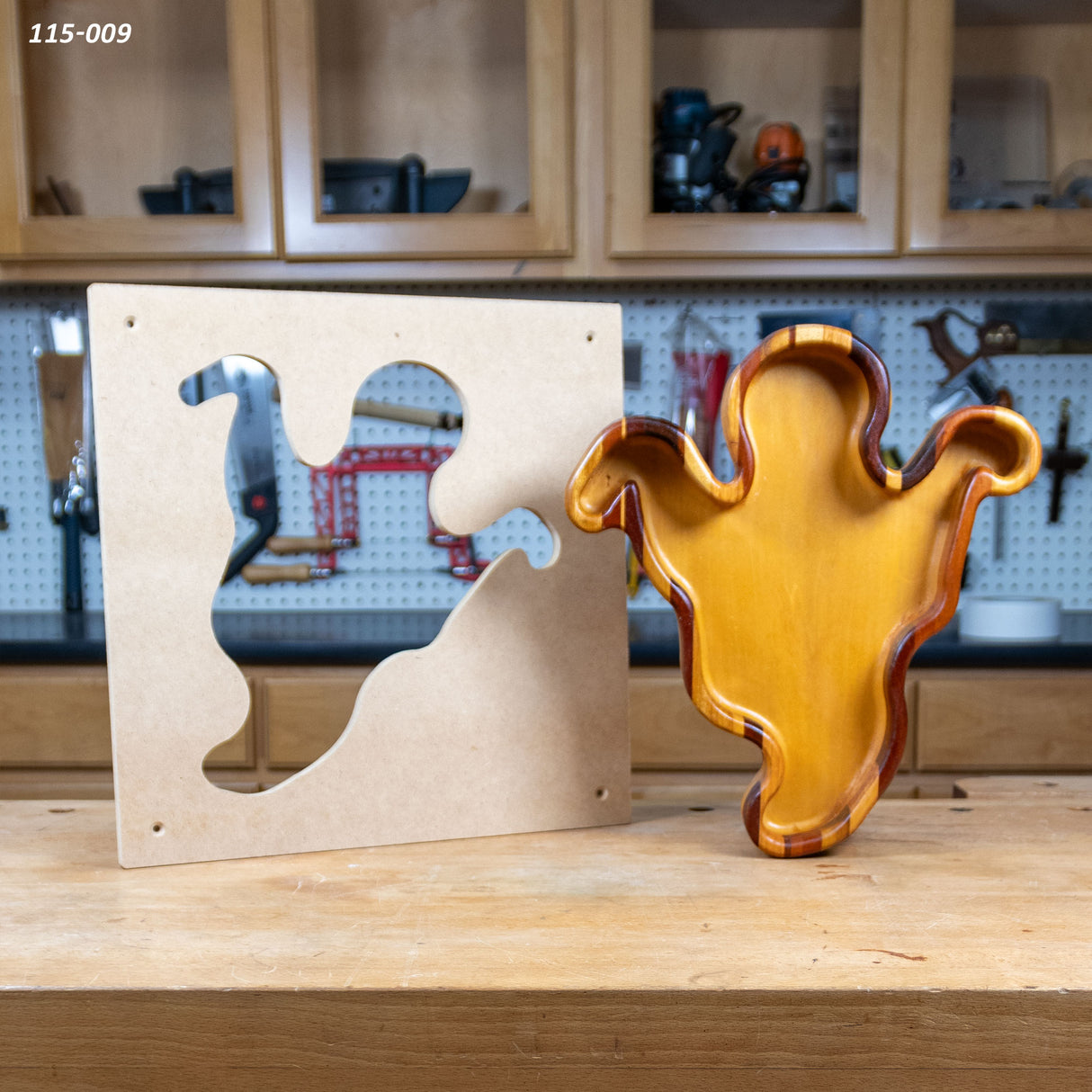 Ghost-shaped woodworking tray and matching MDF template on workshop bench
