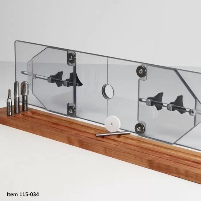 Router table fence with clear acrylic shield and woodworking router bits on wood base