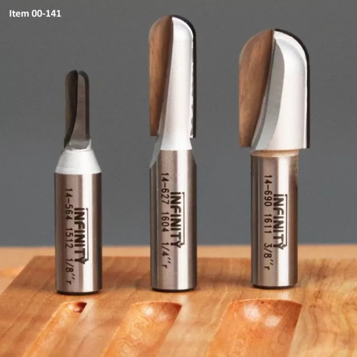 Three woodworking round nose router bits in different sizes on a wooden surface