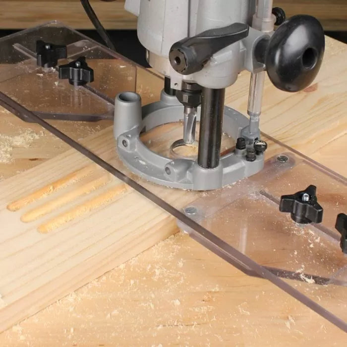 Woodworking router with clear edge guide cutting grooves in a pine board