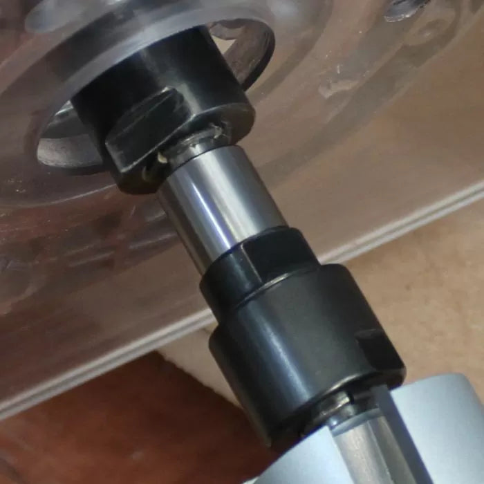 Close-up of a steel woodworking router bit installed in a router table.
