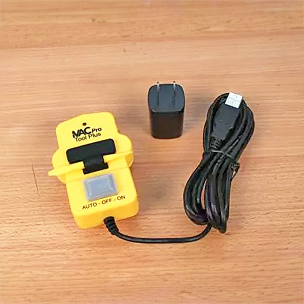 Yellow NAC Pro Tool Plus woodworking tool with power adapter and USB cable on wood surface