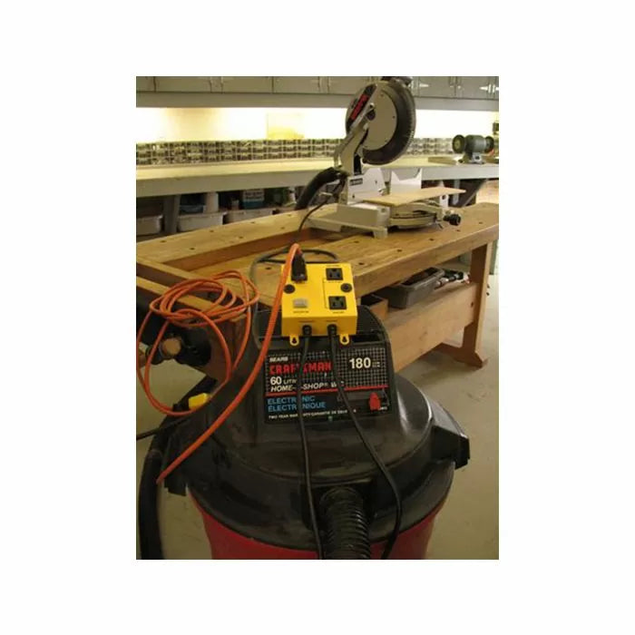 Workshop with miter saw on workbench and wet dry vacuum with power switch box