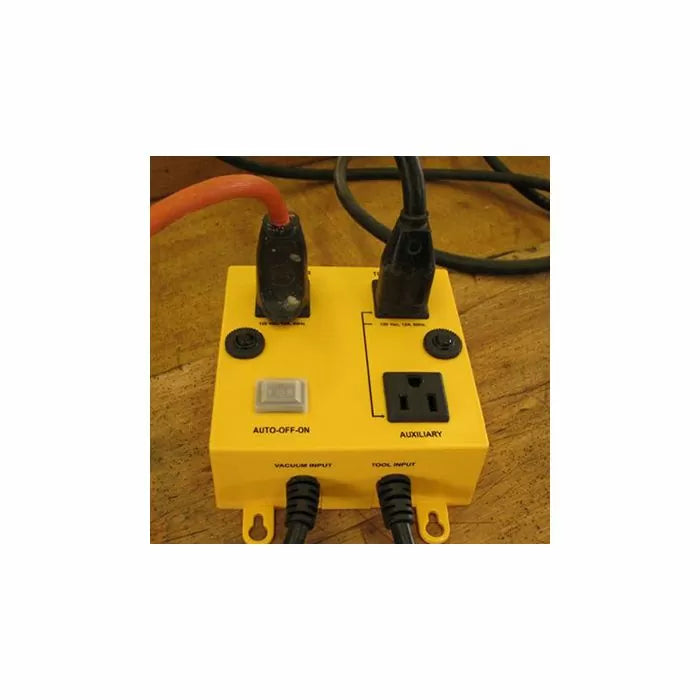 Yellow automatic vacuum switch box with power outlets and tool input on a workbench
