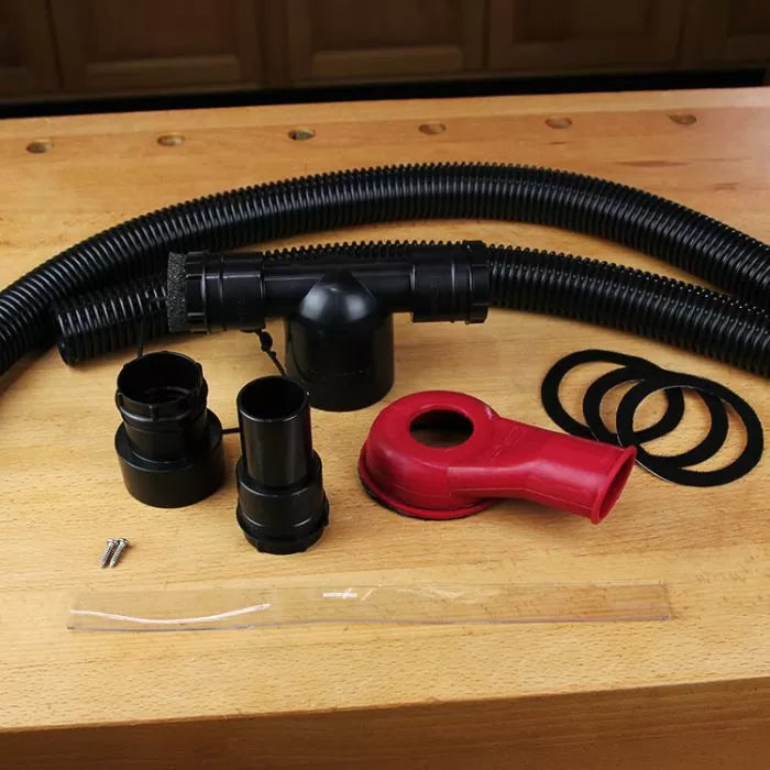 Woodworking dust collection hose kit with adapters, fittings, and seals on a workbench