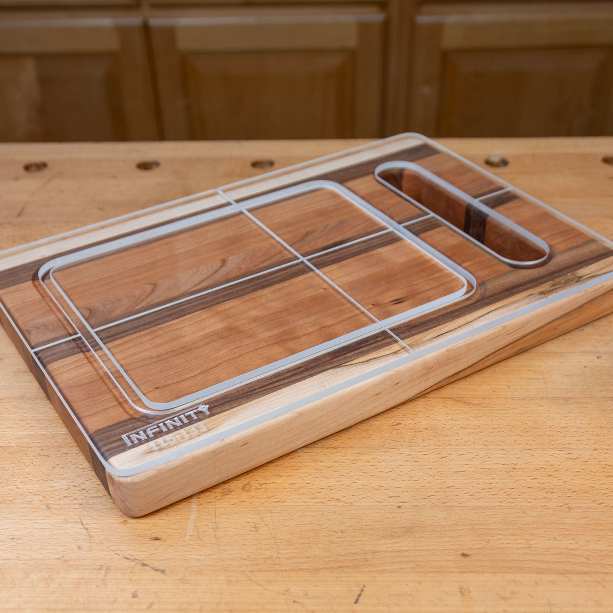 Acrylic cutting board template overlay on wooden cutting board, shown on a workshop table.