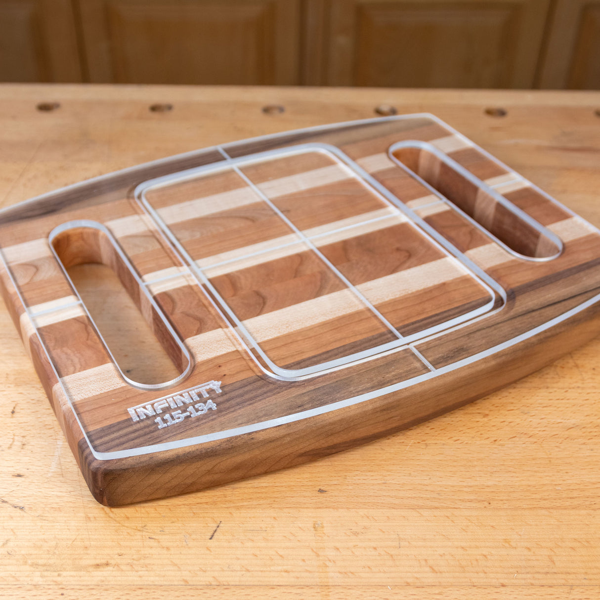 Acrylic cutting board template overlay on a striped wood cutting board with handle slots.