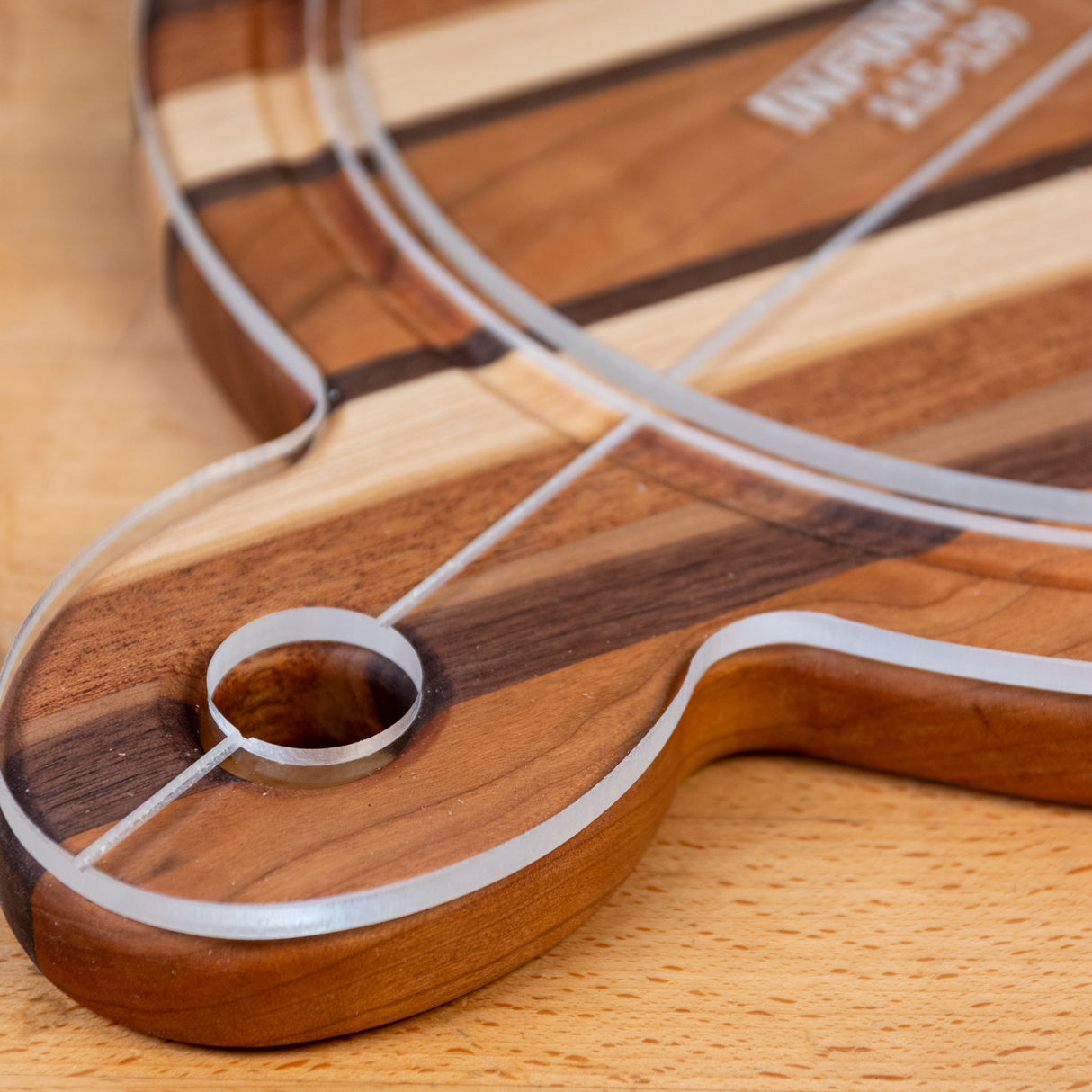 Acrylic cutting board template on striped wood cutting board, close-up detail