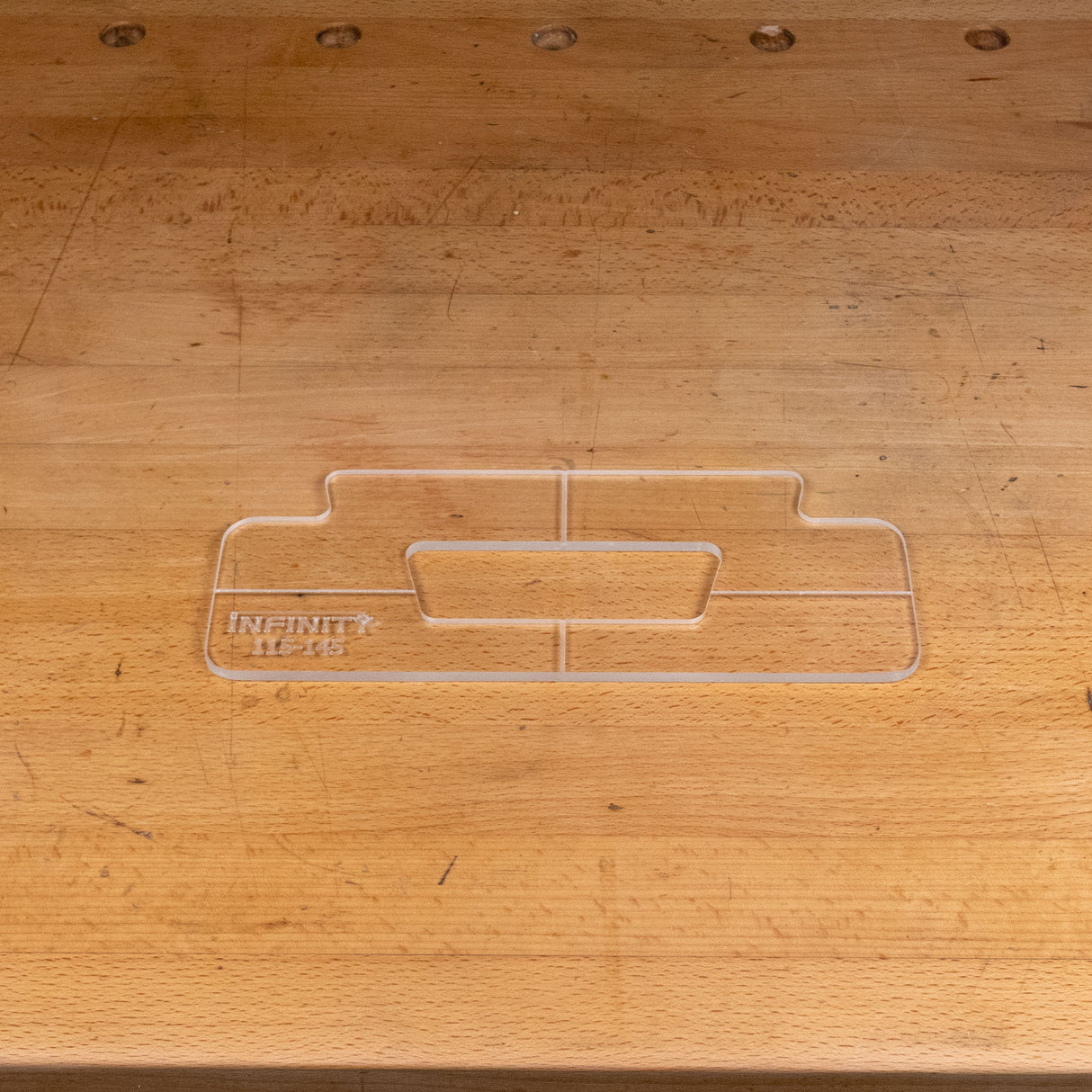 Clear acrylic handle template for woodworking, shown on a wooden workbench