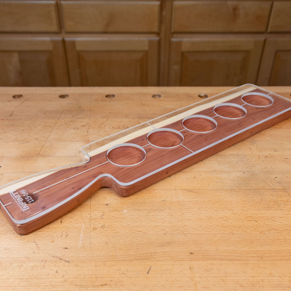 Acrylic cutting board template with circular cutouts on a woodworking bench