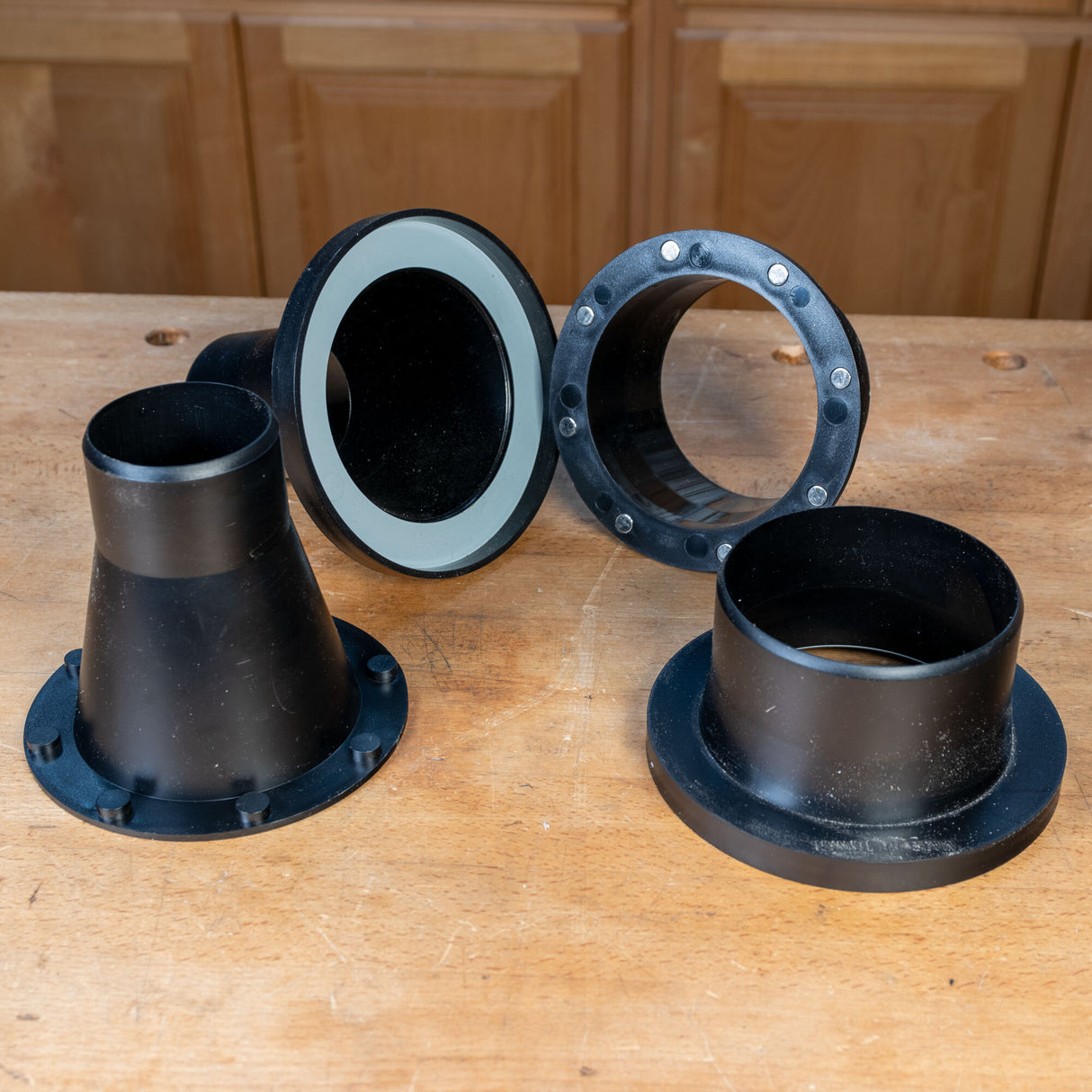 Magnetic dust collection fittings for woodworking, shown on a workshop bench