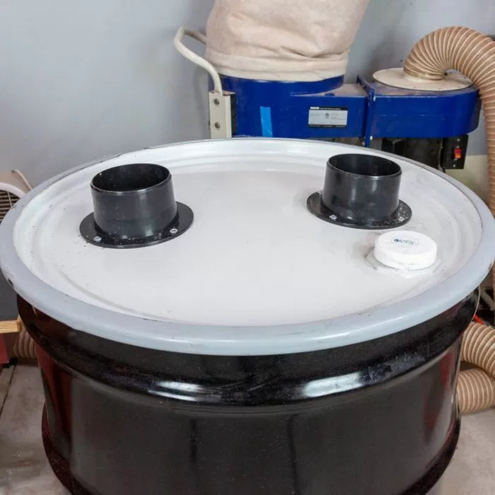 Wood dust separator drum lid with dual hose ports in a workshop dust collection system