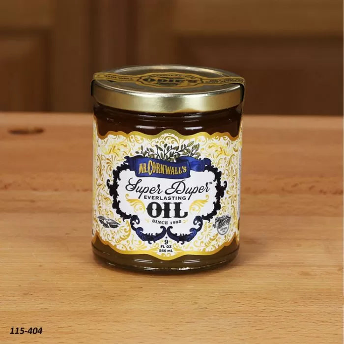 Jar of wood finishing oil on a wooden surface, labeled Super Duper Everlasting Oil.