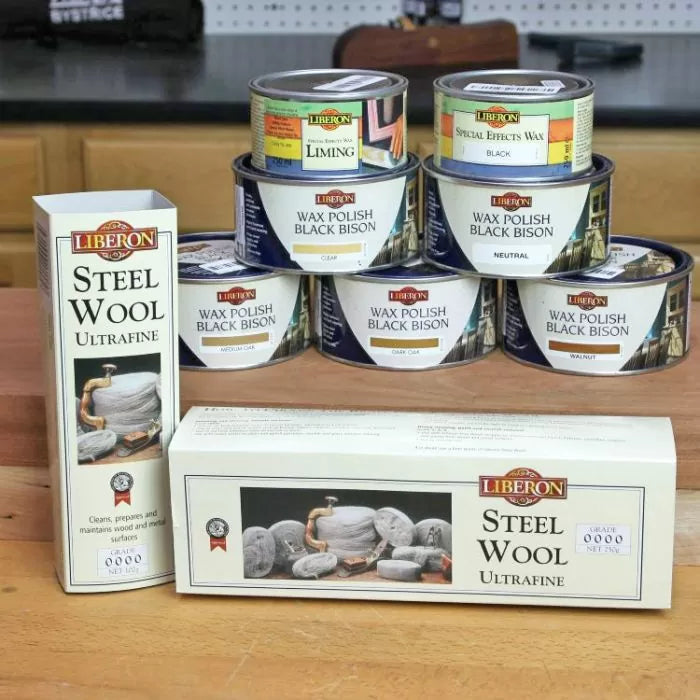 Liberon steel wool and wax polish tins for woodworking on a workshop table