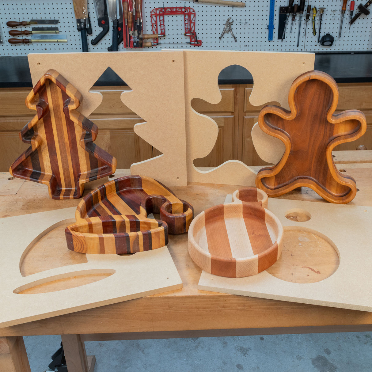 Christmas-themed wooden trays in tree, ornament, stocking, and gingerbread shapes with templates