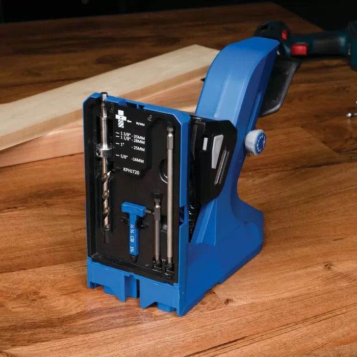Blue pocket hole jig with integrated drill bit storage on a wood workbench