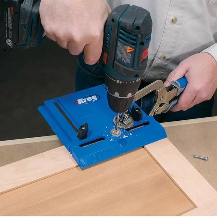 Drilling pocket holes in wood with a blue Kreg jig and power drill for woodworking joinery