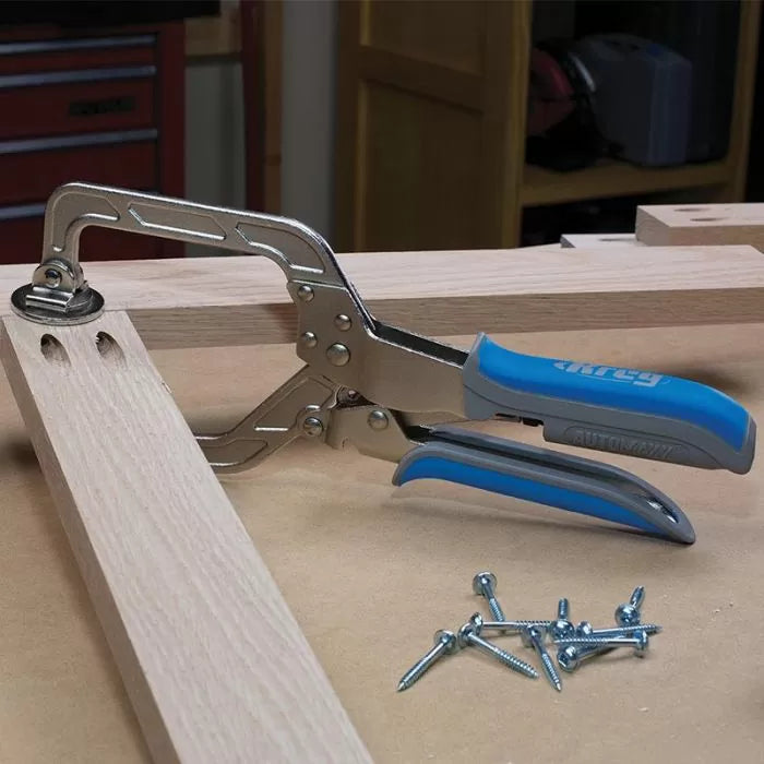 Pocket hole clamp securing wood joint with screws on a woodworking table