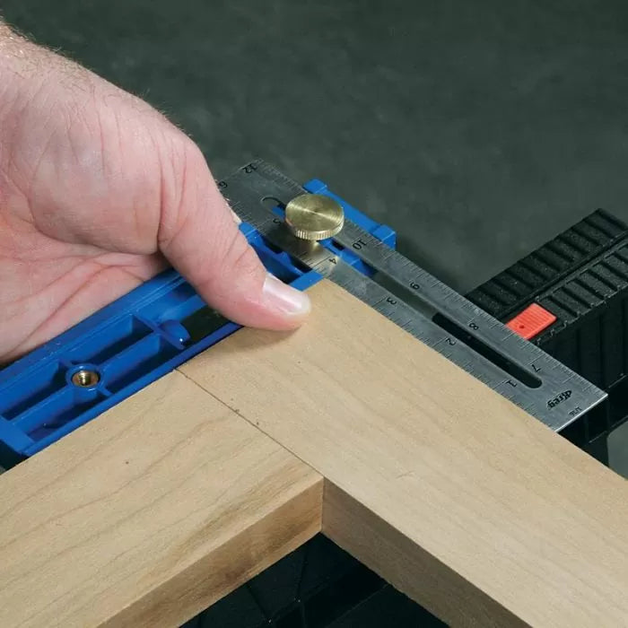 Woodworker using a precision marking gauge and ruler to measure a wood joint