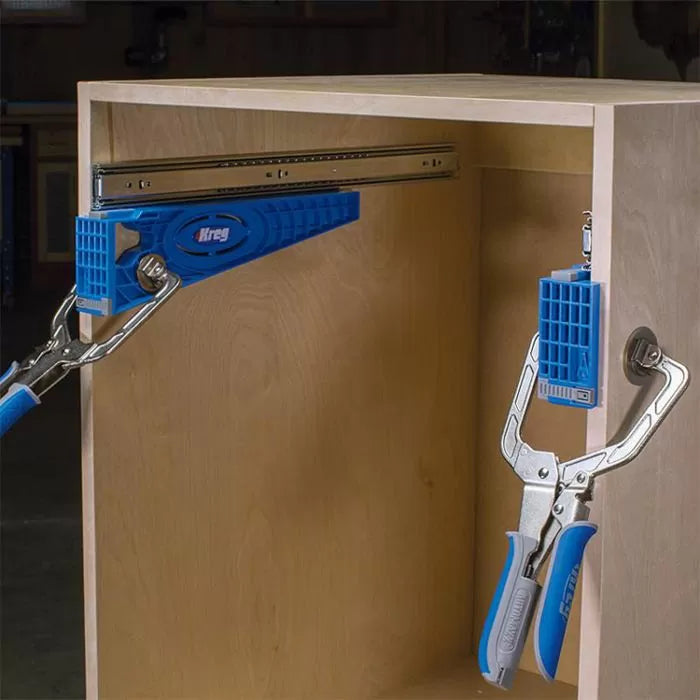 Drawer slide jig clamps attached to a wooden cabinet for precise installation