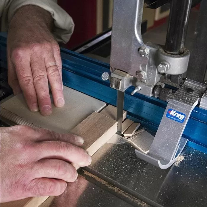 Cutting wood on a bandsaw using a fence for precision woodworking.