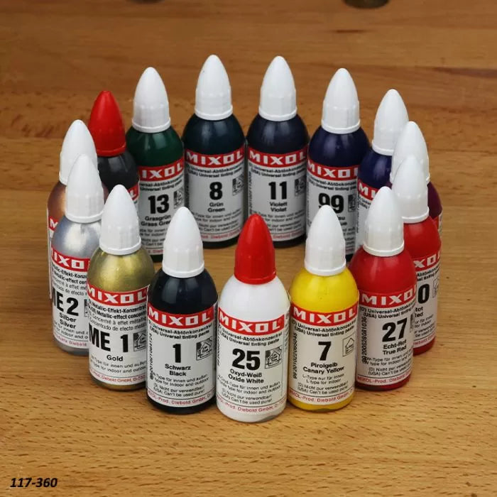 Assorted bottles of Mixol universal tinting concentrates arranged on a wooden surface.