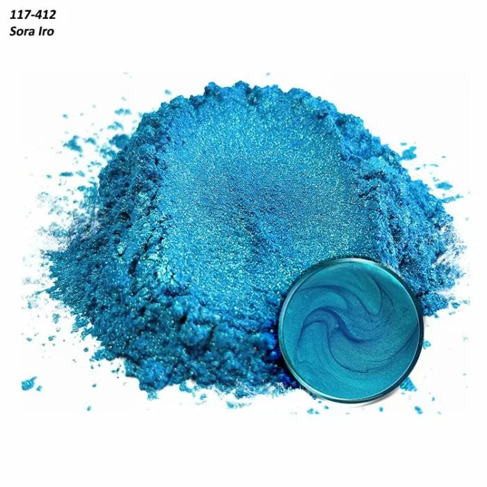 Shimmery blue mica powder pigment with a swirled sample in a metal pan on white background.