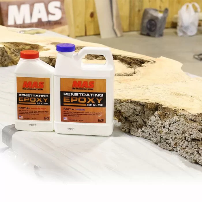 MAS Penetrating Epoxy Sealer bottles on a woodworking table with raw wood slab