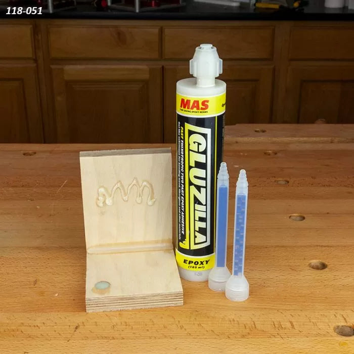 Epoxy adhesive tube with mixing nozzles and a plywood joint on a woodworking bench