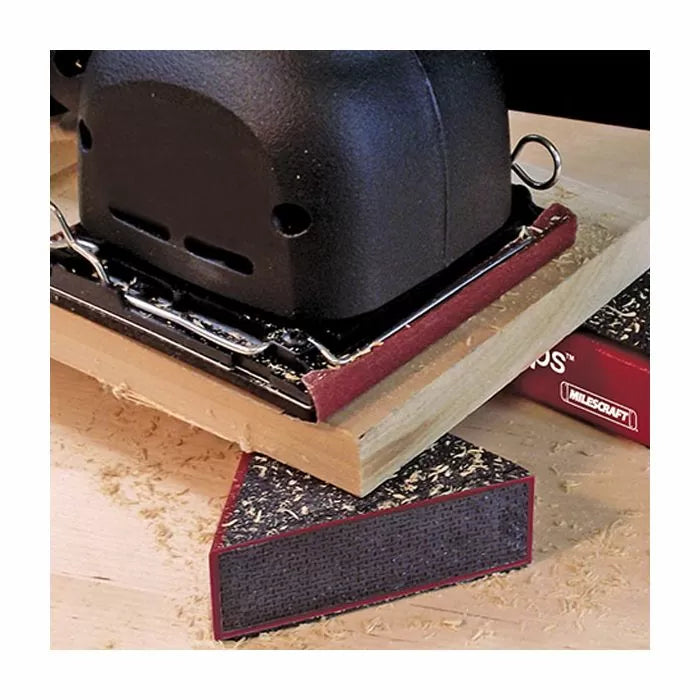 Detail shot of a sanding block and electric sander smoothing a wood edge