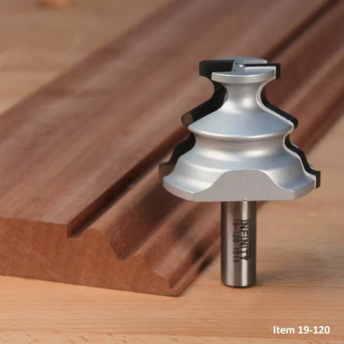 Woodworking router bit with complex profile next to shaped wooden molding on workbench
