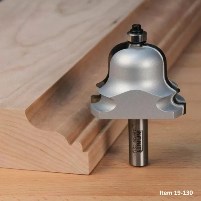 Large ogee router bit beside decorative wood molding on a workbench