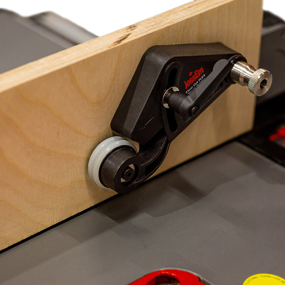 Woodworking router table featherboard with roller guide holding wood against fence