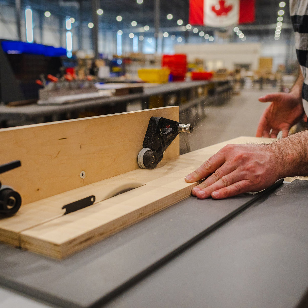 Woodworker using a table saw with push block in a workshop, precise woodworking tool in action