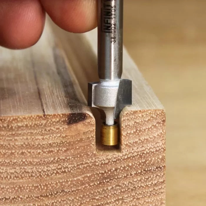 Woodworking router bit creating precise groove in hardwood block