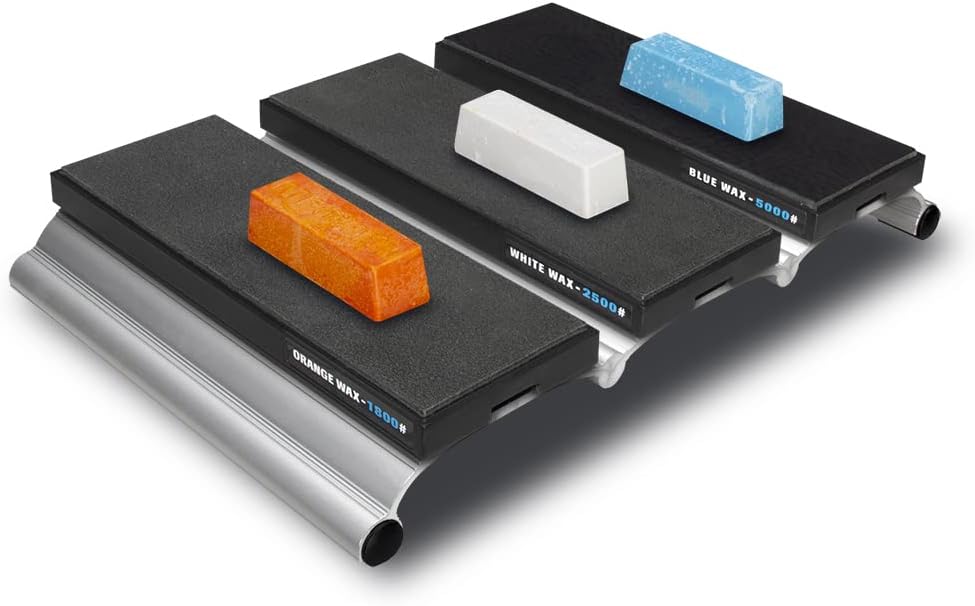 Three sharpening strops with orange, white, and blue wax bars for woodworking tools